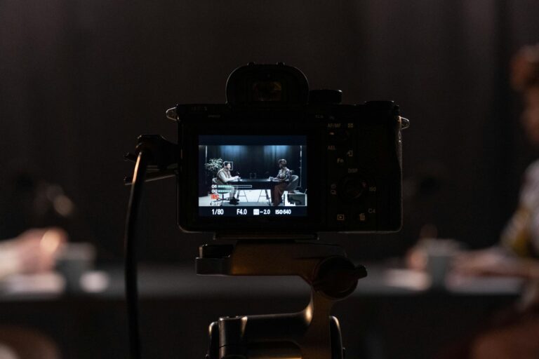 Close-up of a camera recording a podcast interview in a studio setting.